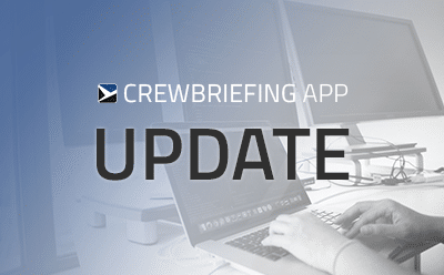 CrewBriefing App Update Graphic promoting a CrewBriefing update, featuring a person typing on a laptop with multiple monitors in the background.