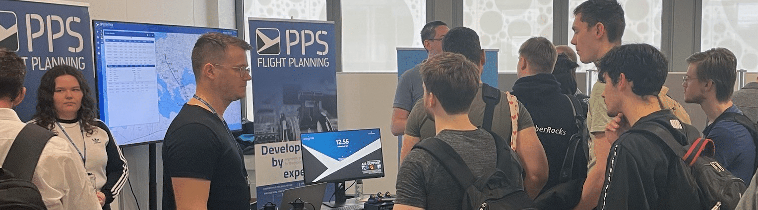 AIR SUPPORT at SDU, Odense, DEN Group of people engaging with PPS Flight Planning representatives at a booth showcasing aviation software solutions and flight tracking.
